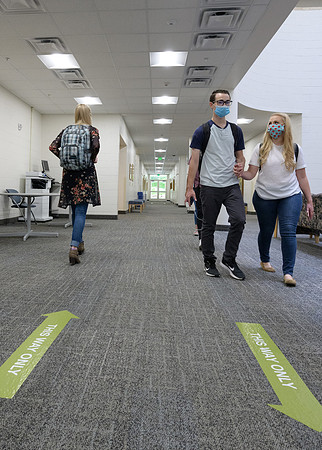 Student volunteers show the way to stay safe during this COVID 19 pandemic by social distancing, following pathway arrows and proper wearing of masks .
