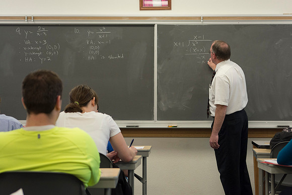 Brother Johanson writes a problem on the chalkboard for his Math 109 Precalculus to solve during the 2014 Spring Semester.