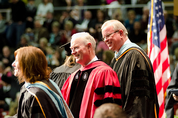 Awarding Diplomas at the College of Business and Communications Convocation. Robyn Bergstrom, Pres. Kim B. Clark and Elder Steven E. Snow greet the graduates.