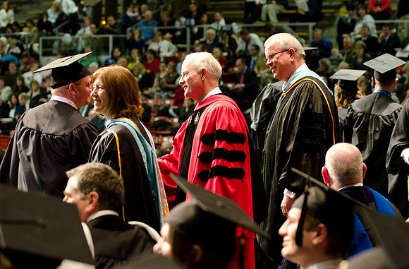 Awarding Diplomas at the College of Business and Communications Convocation. Robyn Bergstrom, Pres. Kim B. Clark and Elder Steven E. Snow greet the graduates.