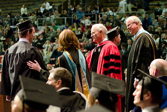 Awarding Diplomas at the College of Business and Communications Convocation. Robyn Bergstrom, Pres. Kim B. Clark and Elder Steven E. Snow greet the graduates.