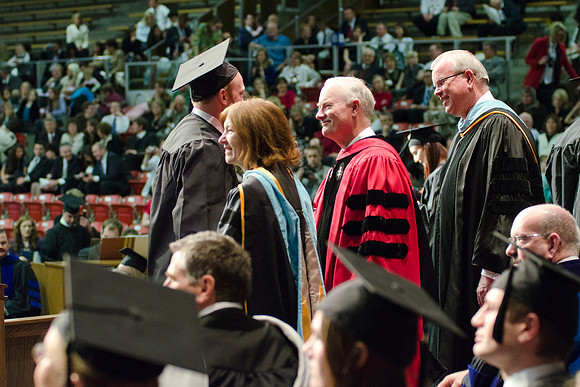 Awarding Diplomas at the College of Business and Communications Convocation. Robyn Bergstrom, Pres. Kim B. Clark and Elder Steven E. Snow greet the graduates.