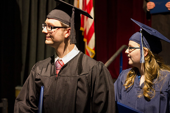 Graduates smile at family and friends as they walk off the stage after Convocation during the 2014 Winter Semester Graduation.