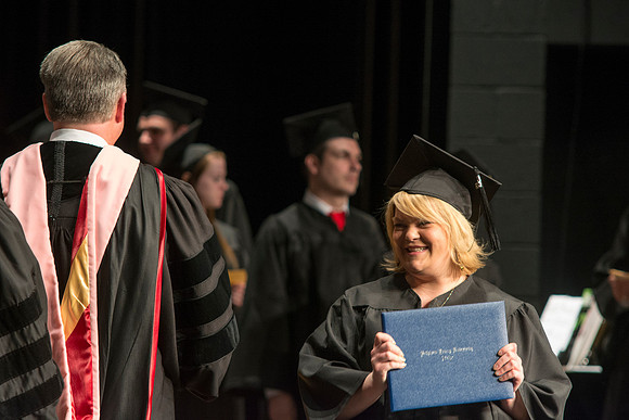 Faculty members hand degrees to and congratualate graduates of the College of Performing and Visual Arts.