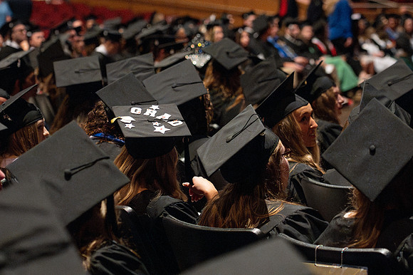 Brother Timothy Rarick laughs with graduates during convocation for the College of Education & Human Development