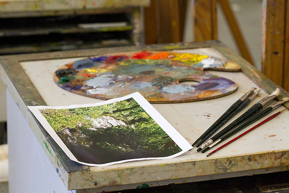 A student's supplies that will be used to paint the beautiful landscape shown.