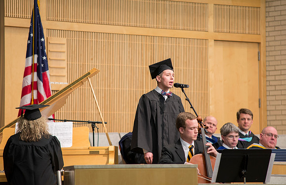 A student singing at graduation.