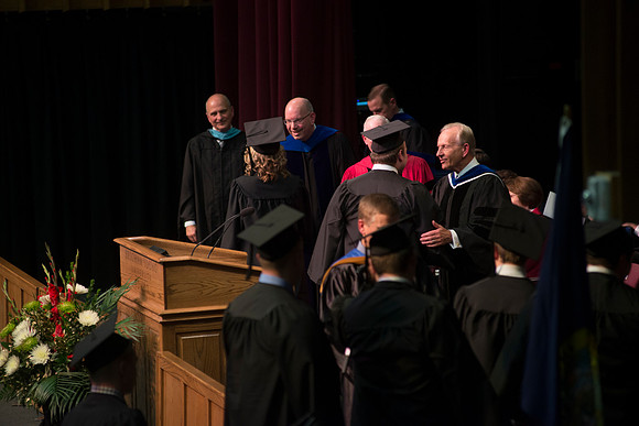Elder W. Craig Zwick and President Kim B. Clark award diploma covers to graduates in the College of Business and Communication.