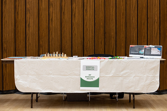 BYU-Idaho Faculty have booths promoting various mental wellness topics. Mix of students and employees mingle among booths.
