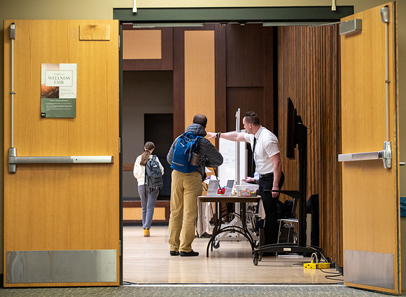 BYU-Idaho Faculty have booths promoting various mental wellness topics. Mix of students and employees mingle among booths.