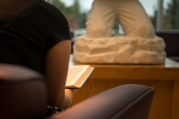 A student studies the scriptures before devotional in the Hinckley Building.