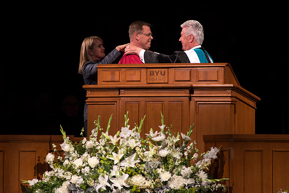 President Uchtdorf presents Clark G. Gilbert with his medallion. Sister Gilbert helps fasten it.