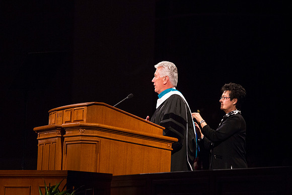 Sister Uchtdorf fixes President Uchtdorf's robe during his remarks.