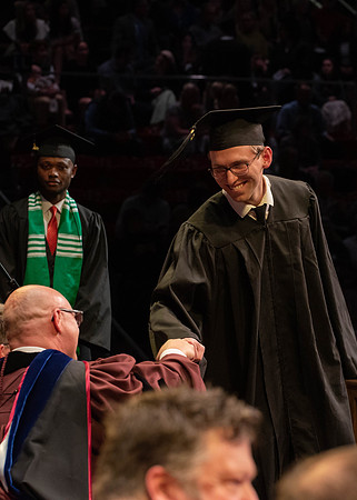 Students graduate and walk to receive their diplomas during convocation in the College of Physical Sciences and Engineering.