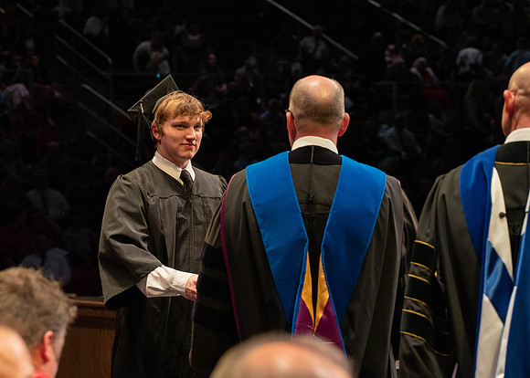 Students graduate and walk to receive their diplomas during convocation in the College of Physical Sciences and Engineering.