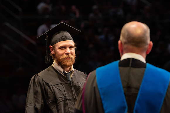 Students graduate and walk to receive their diplomas during convocation in the College of Physical Sciences and Engineering.