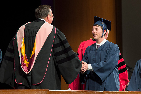 Students of the College of Agriculture and Life Sciences walk across the stage and receive their diplomas.