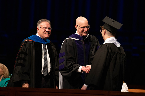 Students graduate and walk to recieve their diplomas during convocation in the College of Business and Communications.