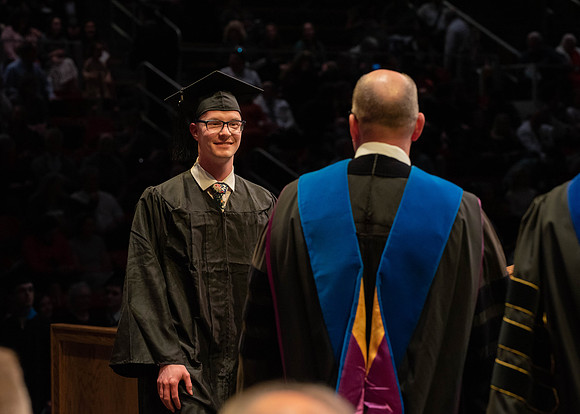 Students graduate and walk to receive their diplomas during convocation in the College of Physical Sciences and Engineering.