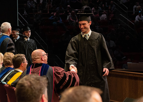 Students graduate and walk to receive their diplomas during convocation in the College of Physical Sciences and Engineering.