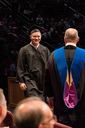 Students graduate and walk to receive their diplomas during convocation in the College of Physical Sciences and Engineering.