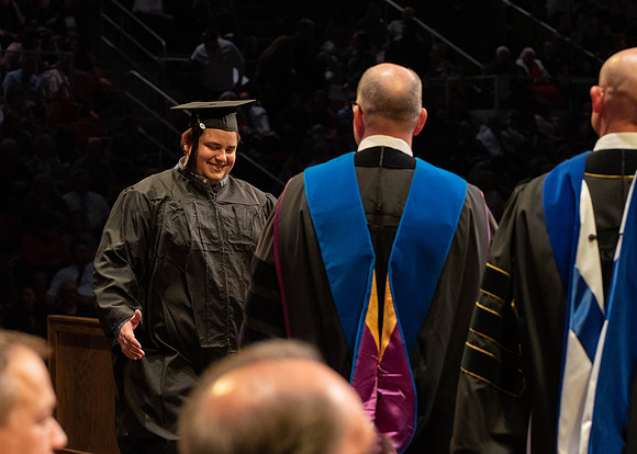 Students graduate and walk to receive their diplomas during convocation in the College of Physical Sciences and Engineering.
