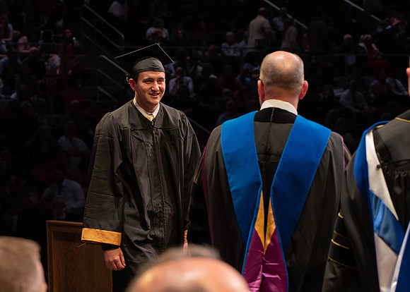 Students graduate and walk to receive their diplomas during convocation in the College of Physical Sciences and Engineering.