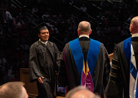 Students graduate and walk to receive their diplomas during convocation in the College of Physical Sciences and Engineering.
