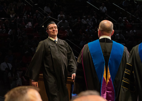 Students graduate and walk to receive their diplomas during convocation in the College of Physical Sciences and Engineering.