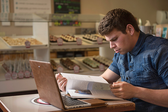 Blake Jensen studies for an Online class at the Cocoa Bean Cafe in Rexburg, ID.