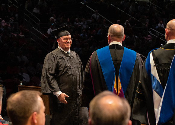 Students graduate and walk to receive their diplomas during convocation in the College of Physical Sciences and Engineering.