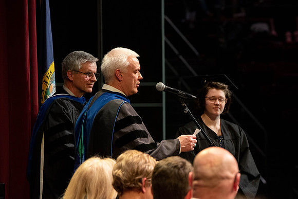 Students graduate and walk to receive their diplomas during convocation in the College of Physical Sciences and Engineering.