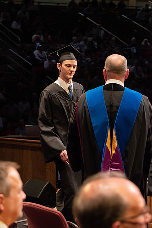 Students graduate and walk to receive their diplomas during convocation in the College of Physical Sciences and Engineering.