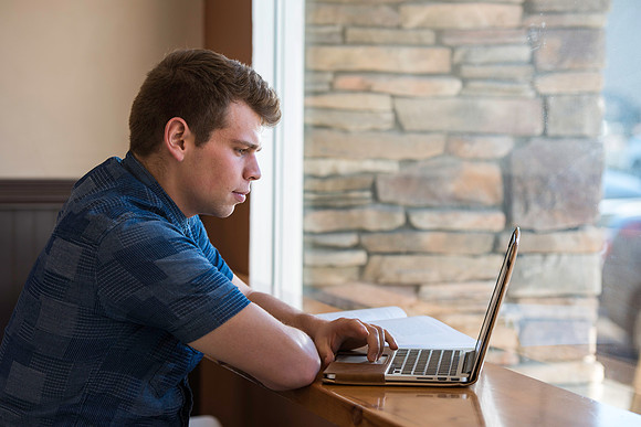 Blake Jensen studies for an Online class at the Cocoa Bean Cafe in Rexburg, ID.