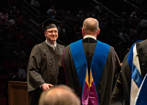 Students graduate and walk to receive their diplomas during convocation in the College of Physical Sciences and Engineering.
