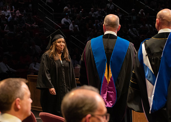 Students graduate and walk to receive their diplomas during convocation in the College of Physical Sciences and Engineering.