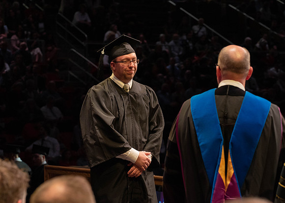 Students graduate and walk to receive their diplomas during convocation in the College of Physical Sciences and Engineering.
