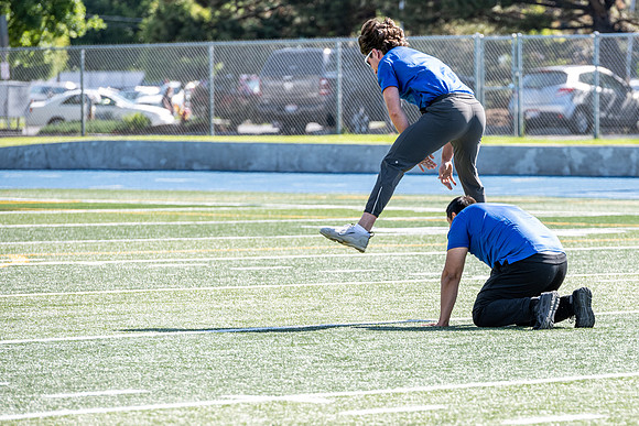 Coaches teach younger kids ages 12-16 exercise drills on the BYU-Idaho stadium field at a speed and agility camp.