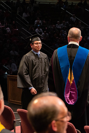 Students graduate and walk to receive their diplomas during convocation in the College of Physical Sciences and Engineering.