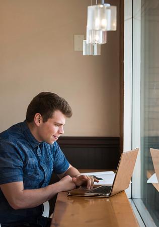 Blake Jensen studies for an Online class at the Cocoa Bean Cafe in Rexburg, ID.