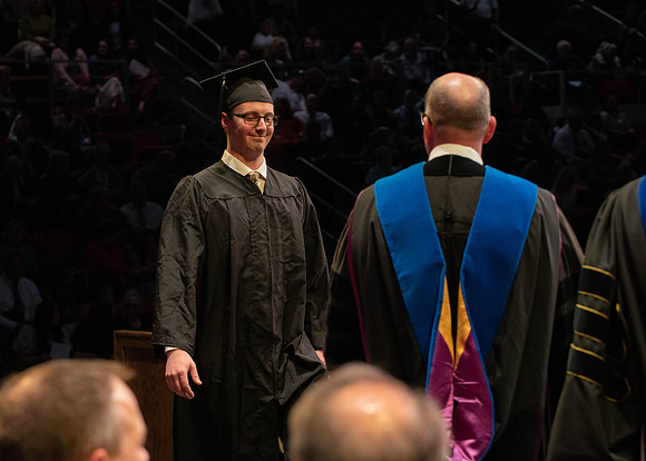 Students graduate and walk to receive their diplomas during convocation in the College of Physical Sciences and Engineering.