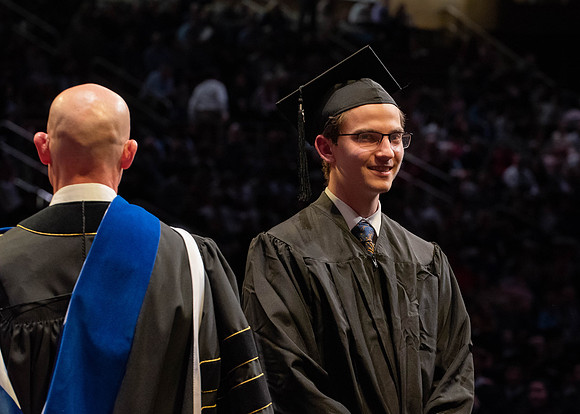 Students graduate and walk to receive their diplomas during convocation in the College of Physical Sciences and Engineering.