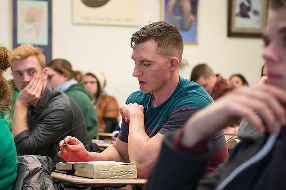 Students help and teach one another in Brother Peterson's religion class.