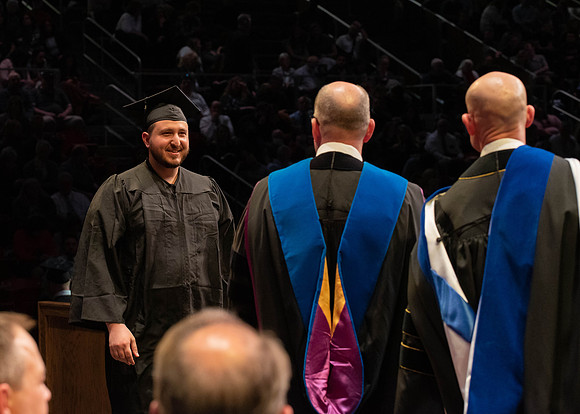 Students graduate and walk to receive their diplomas during convocation in the College of Physical Sciences and Engineering.