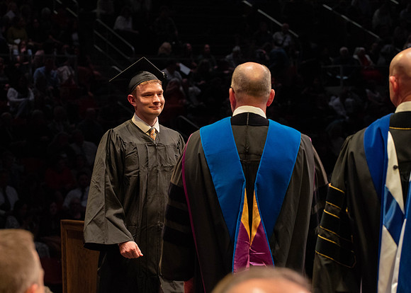 Students graduate and walk to receive their diplomas during convocation in the College of Physical Sciences and Engineering.