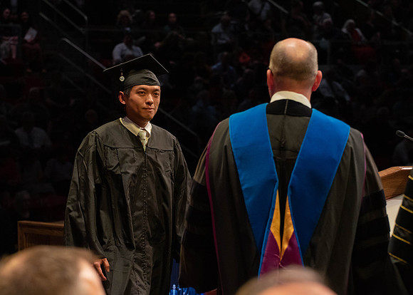 Students graduate and walk to receive their diplomas during convocation in the College of Physical Sciences and Engineering.