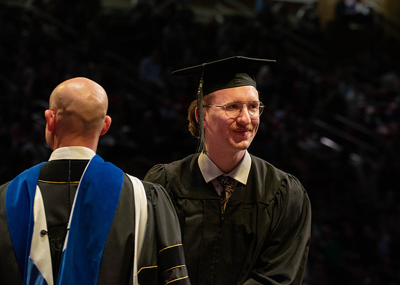 Students graduate and walk to receive their diplomas during convocation in the College of Physical Sciences and Engineering.