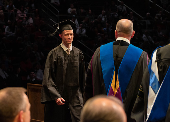 Students graduate and walk to receive their diplomas during convocation in the College of Physical Sciences and Engineering.