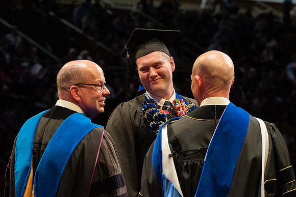 Students graduate and walk to receive their diplomas during convocation in the College of Physical Sciences and Engineering.