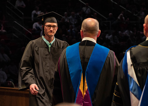 Students graduate and walk to receive their diplomas during convocation in the College of Physical Sciences and Engineering.